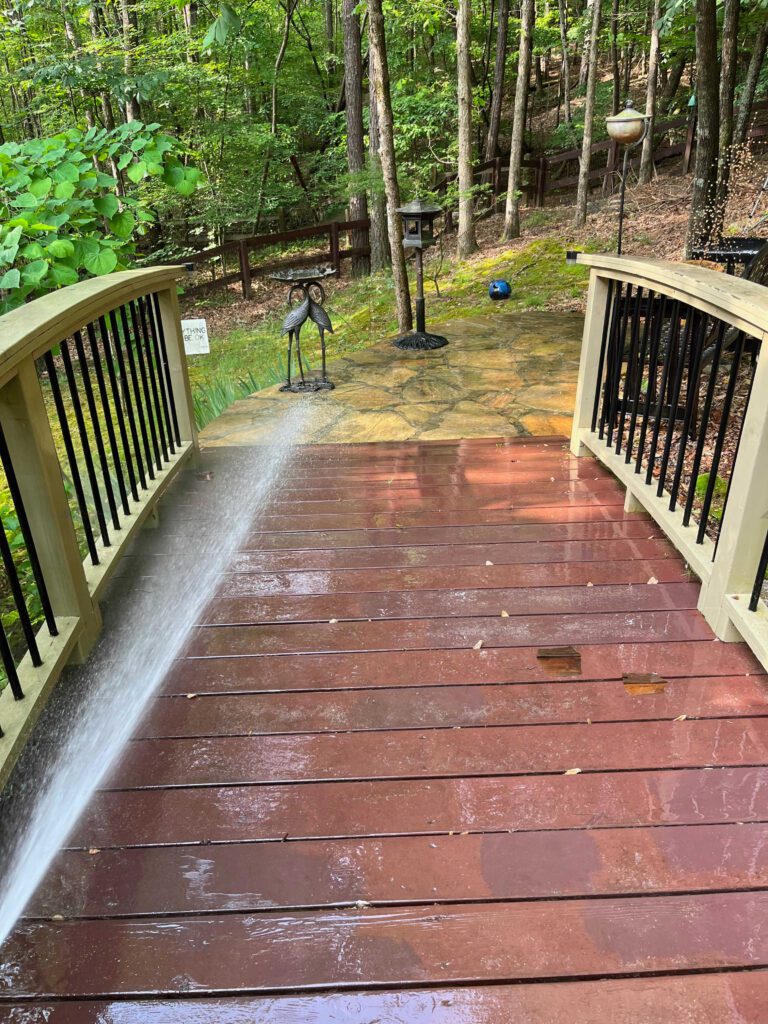 Pressure washer removing mold from wooden deck - photo